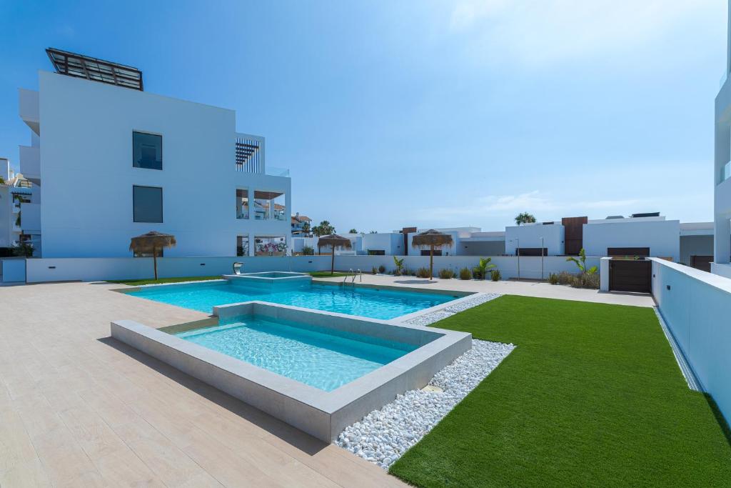 a swimming pool on the roof of a building at LA Paz - Sunny Pool Retreat - Jacuzzi - Near Beach in Los Alcázares