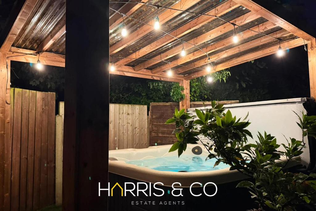 a hot tub in a backyard with a pergola at Poolfoot Villas in Thornton