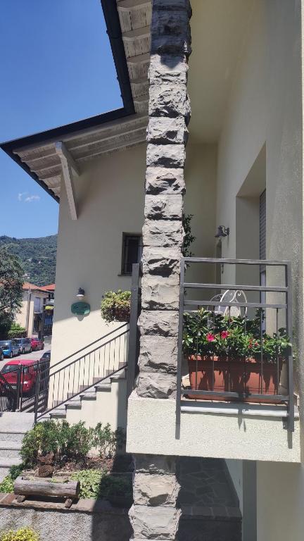 a balcony of a house with flowers inpots on it at LORA GIUSTA GUEST HOUSE in Como