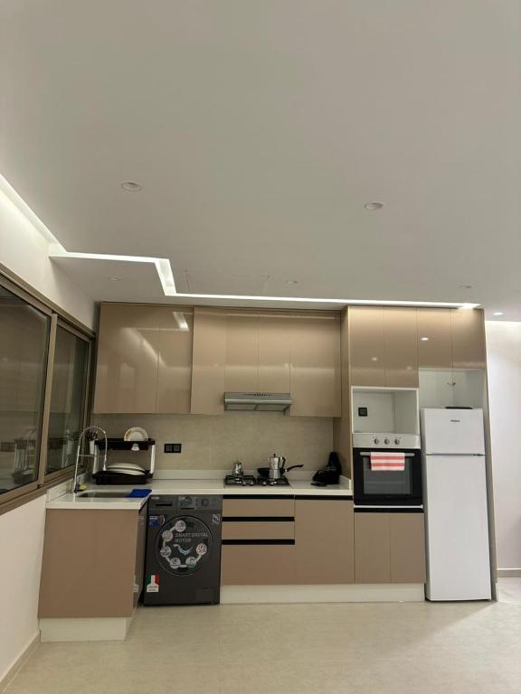 a kitchen with a stove and a refrigerator at Igar Azougagh Immeuble DII in Al Hoceïma