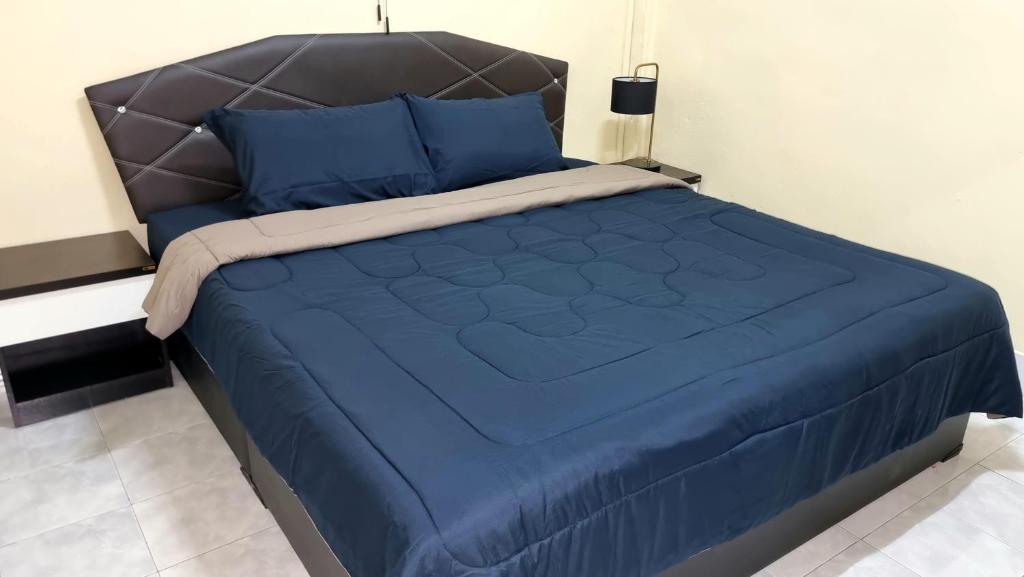 a bed with a blue comforter and blue pillows at La Belle Cliff View in Ao Nang Beach