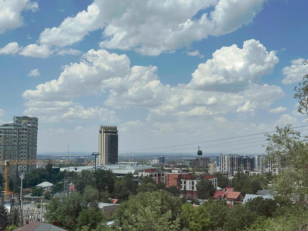 a view of a city with clouds in the sky at Altura House in Almaty