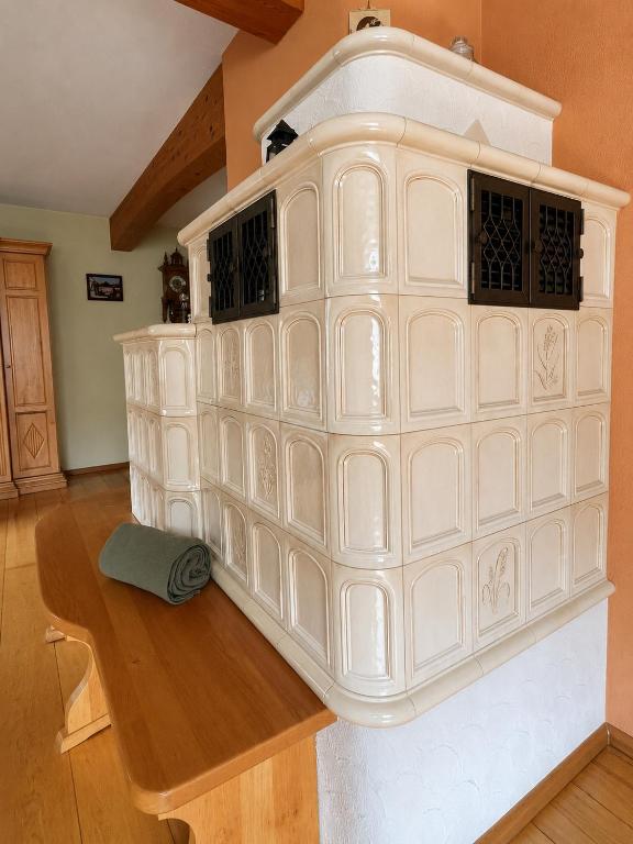 a white fireplace in a room with a wooden table at Ferienwohnung Grebe in Breidenbach