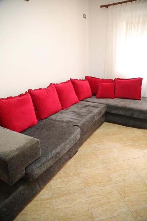 a long couch with red pillows in a room at Prim Guest House in Këlcyrë
