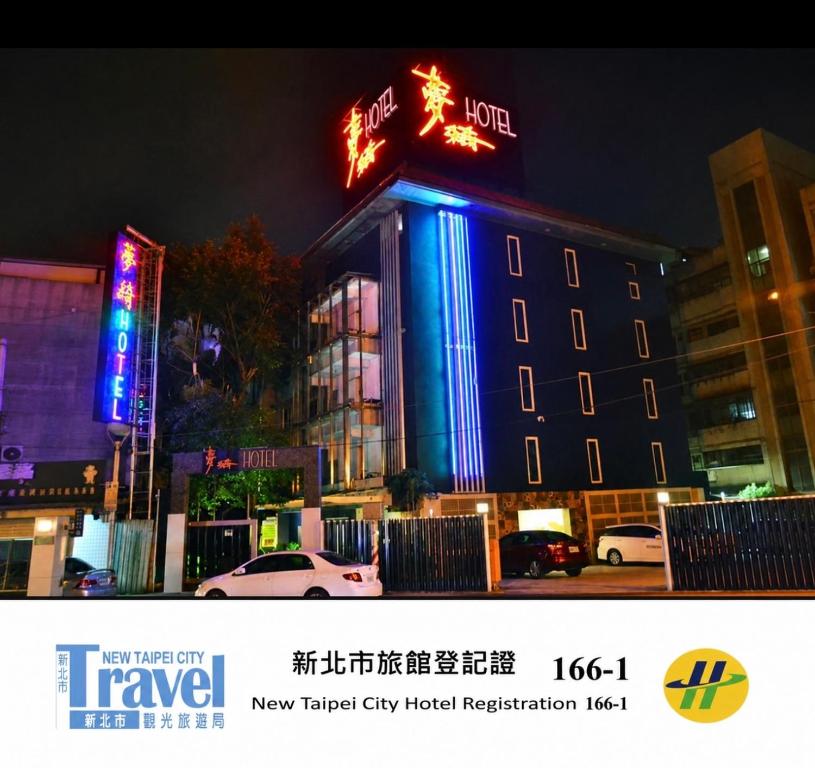a hotel building with a neon sign on it at Meng Qi Hotel in Taipei