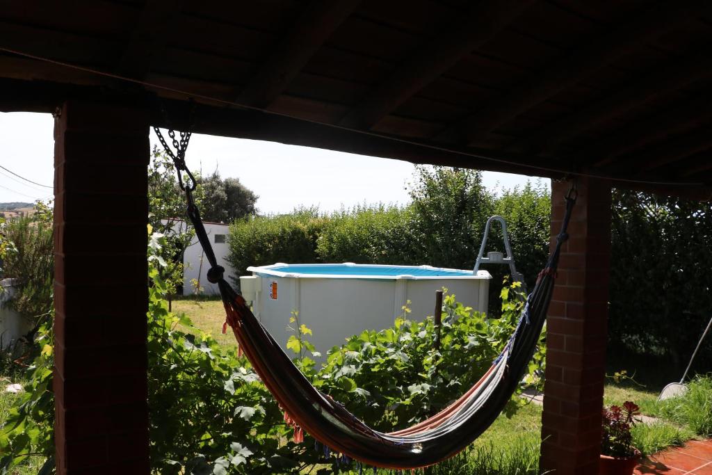 a hammock with a bucket in a garden at C M Casa de Mares Alojamento Local in Casas Novas de Marés