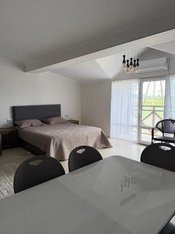 a bedroom with a bed and a table and chairs at Raduga West 19-9 in Koshkolʼ