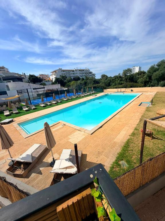 a large swimming pool with lounge chairs at Marachique Beach Flat in Alvor