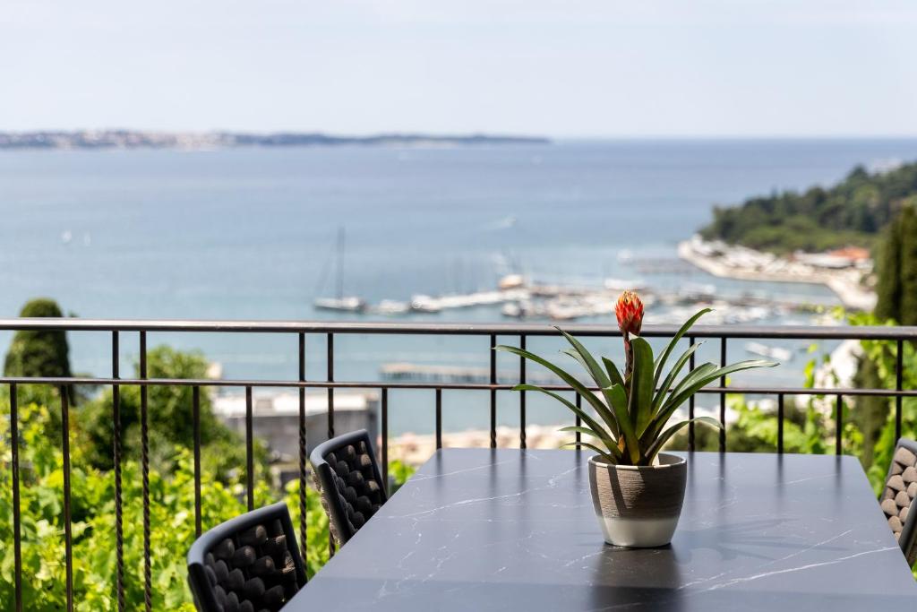 a table with a flower in a pot on a balcony at LUX Dolce Vista Apartment - Portorož in Portorož
