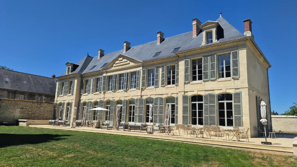 a large white building with a roof at Château de l'Abbatiale in Braine