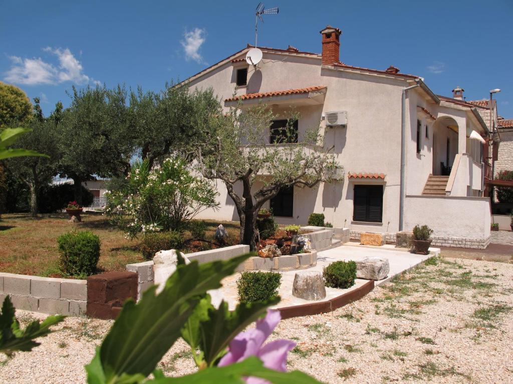 a house with a garden in front of it at Apartments Roza in Rošini