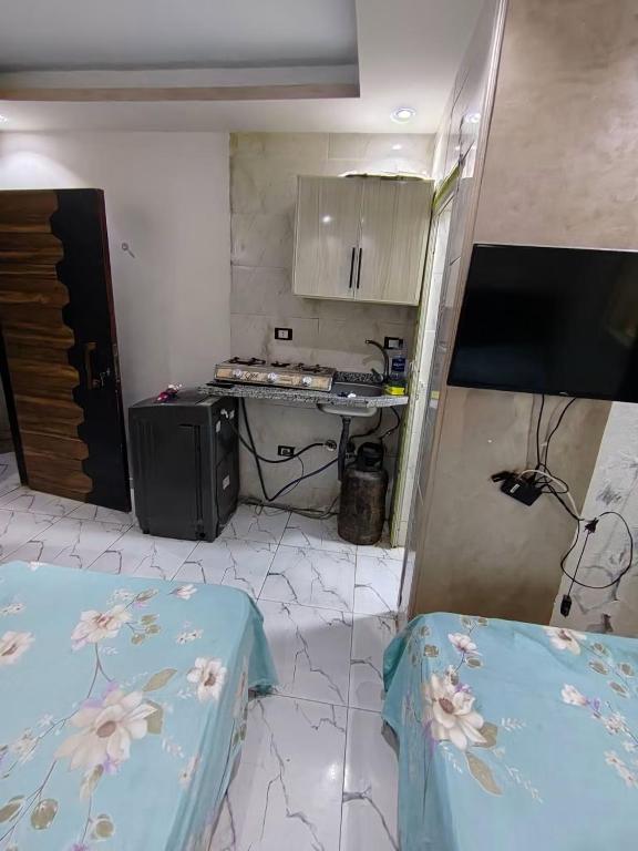 a small kitchen with two beds in a room at Hekmt home in Kafr al Ishārah