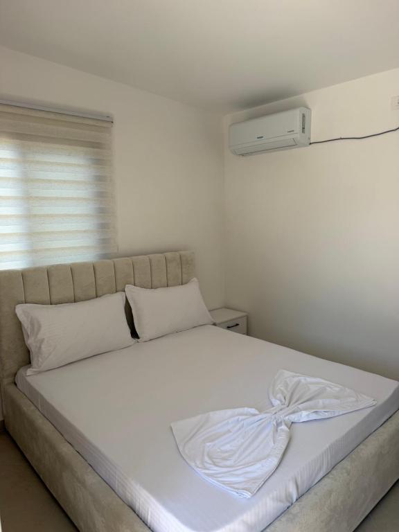 a white bed with a white blanket on it at Casa vacanze Cape Rodon in Draç