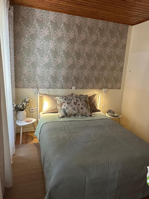 ein Schlafzimmer mit einem Bett und einer grauen Wand in der Unterkunft Central Spot 9 in Korfu-Stadt