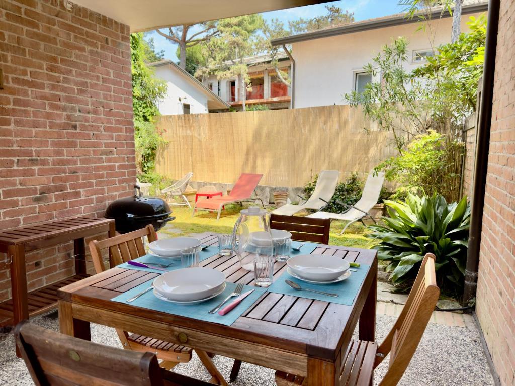 a wooden table and chairs on a patio at Villa Tamerici - Garden & Parking in Lignano Sabbiadoro