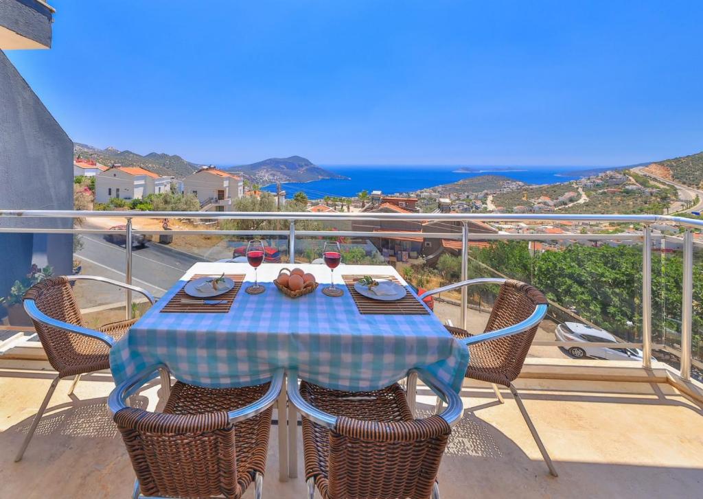 a table and chairs on a balcony with a view of the ocean at Apollon Apartment in Kalkan