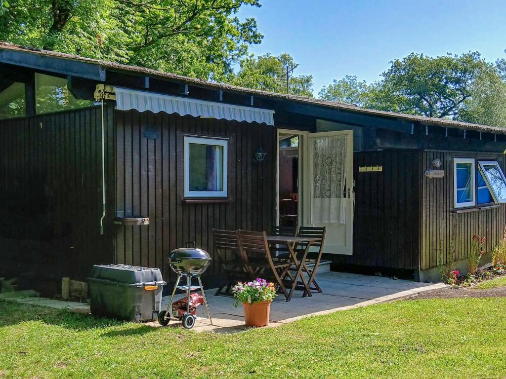 a small cabin with a grill and a patio at Noddfa in Newcastle Emlyn