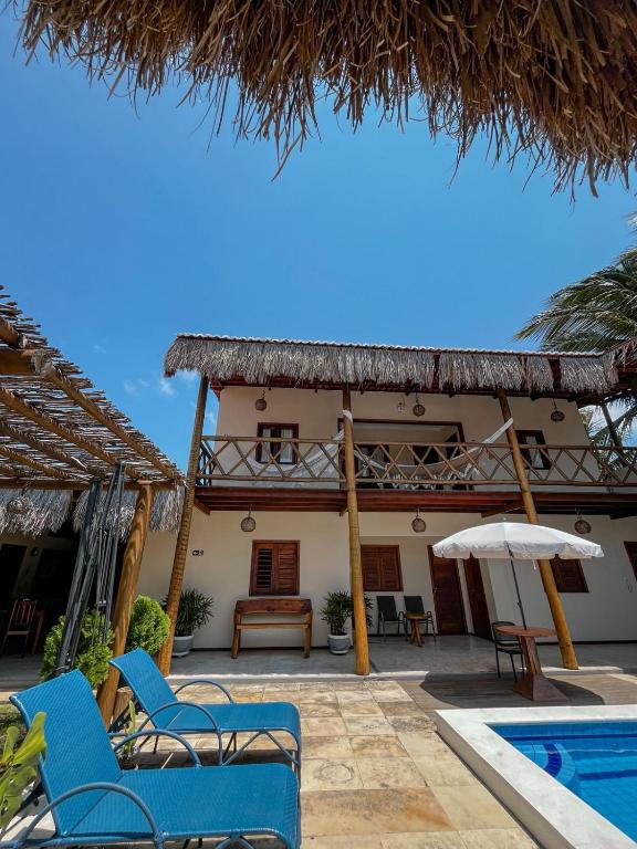 a resort with a pool and chairs and a building at Pousada Canaã Icaraizinho in Amontada