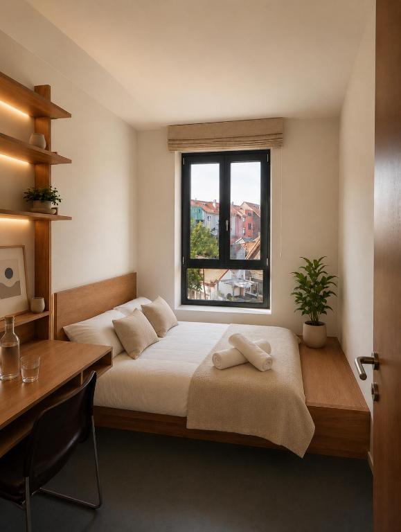 a bedroom with two beds and a desk and a window at Maison Bruxelles in Brussels