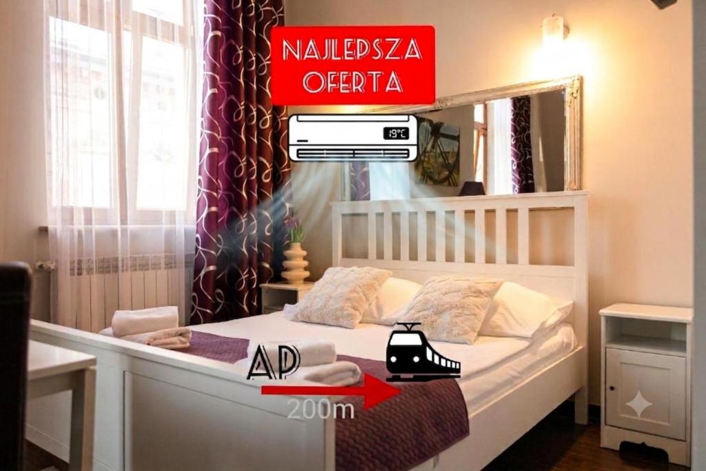 a bedroom with a white bed with a sign on it at Apartamenty Przemyśl in Przemyśl