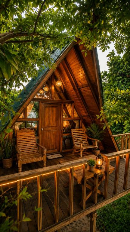 a cabin in the woods with two chairs and a table at Wilpattu Green Cabin in Achchamulai
