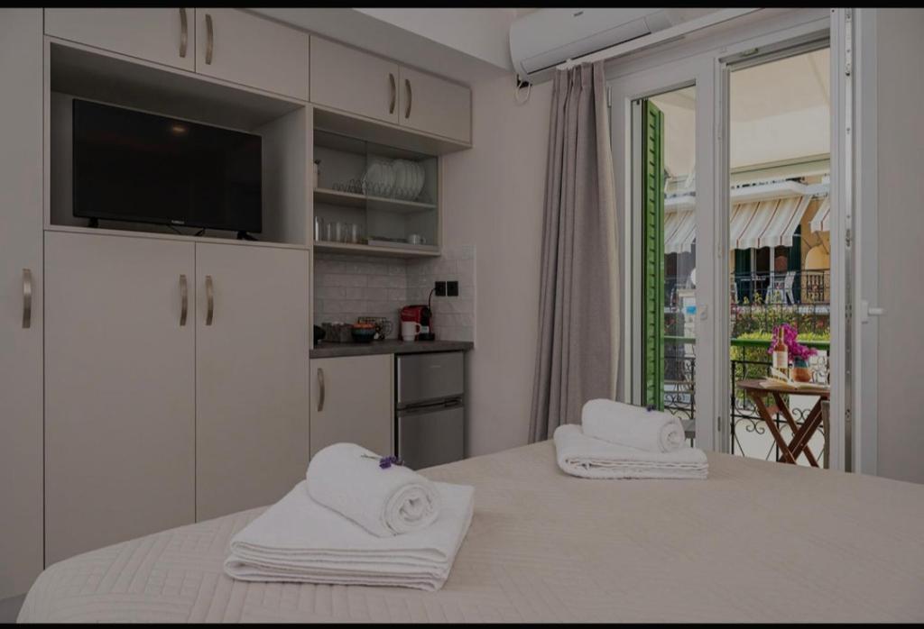 a kitchen with white cabinets and towels on a table at Dimitra Suites in Pythagoreio