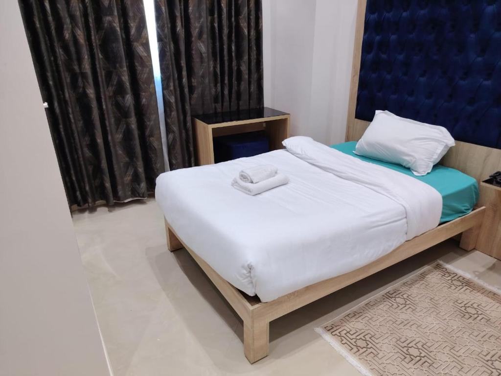 a small bedroom with a bed with white sheets at KA Hôtel Dely Ibrahim in Deli Ibrahim