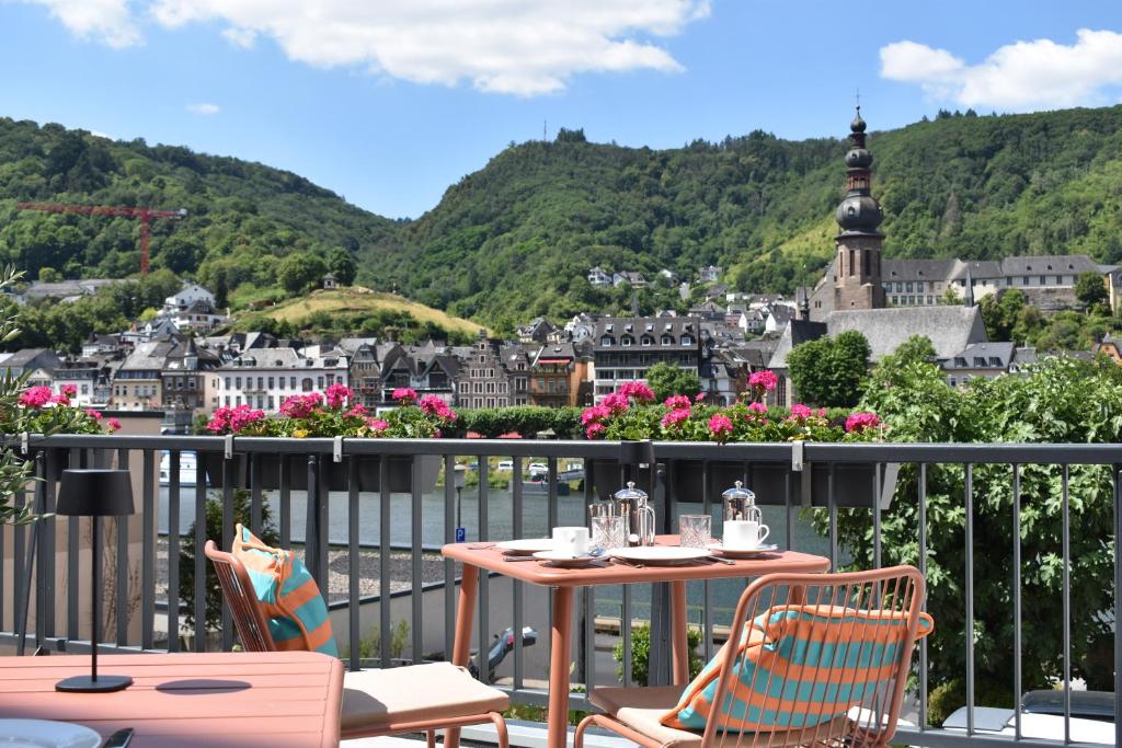 a table and chairs on a balcony with a view of a city at Lipmanns Boutique-Hotel in Cochem