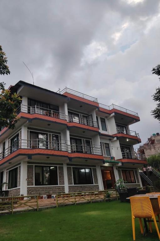 an apartment building with balconies and a yard at Hotel Indrawoti and Resort in Dhulikhel
