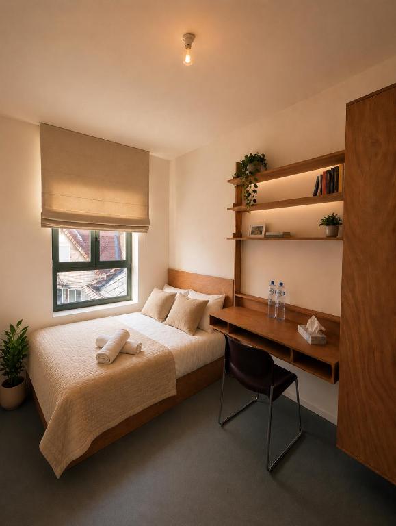 a bedroom with a bed and a desk and a window at Maison Bruxelles in Brussels