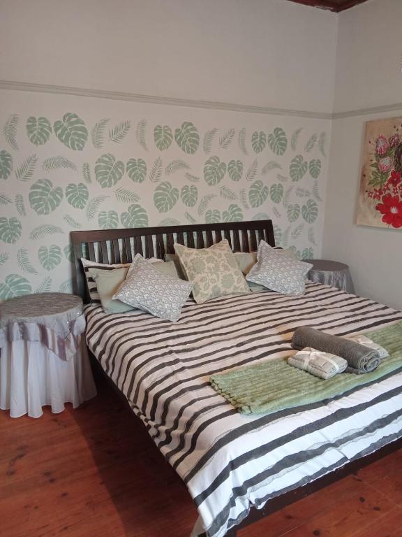 a bedroom with a bed with a striped comforter at Feather Foot Self catering Accommodation in Heidelberg