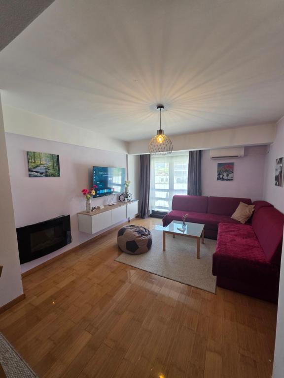 a living room with a purple couch and a table at Apartment Love in Vlasic