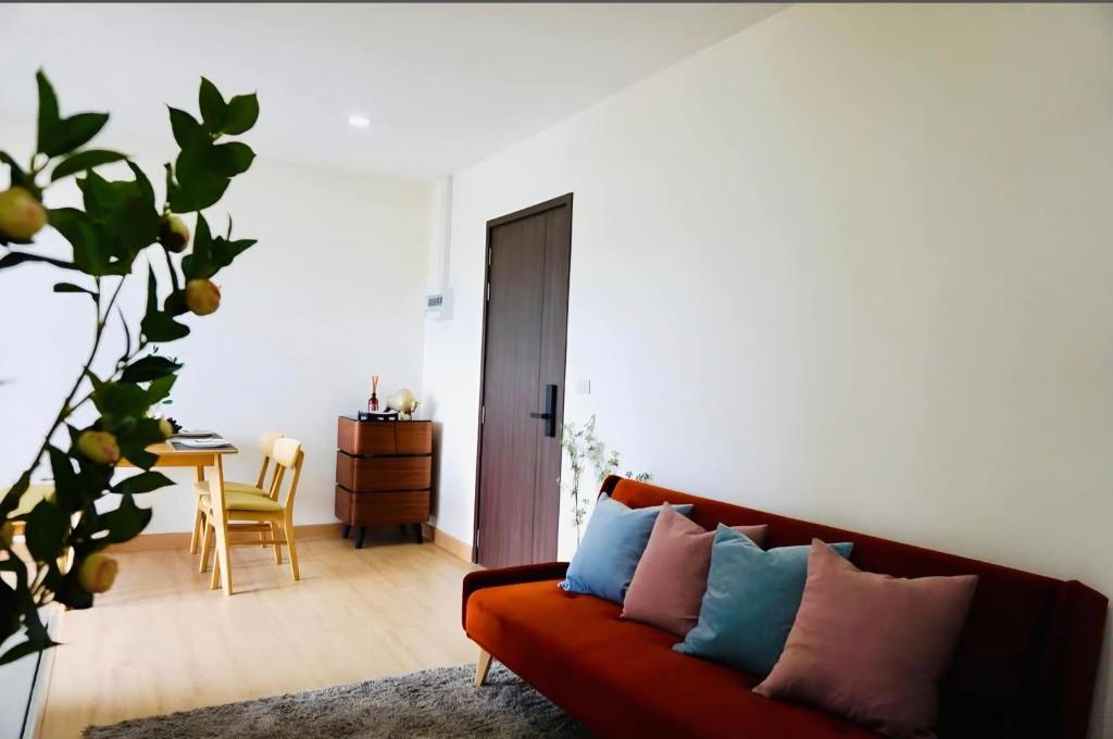 a living room with a red couch with colorful pillows at condoTip in Loei