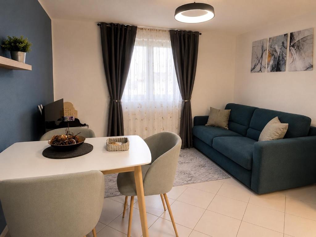 a living room with a blue couch and a table at Gemütliche Wohnung am Bodensee - Self-CheckIn in Markdorf