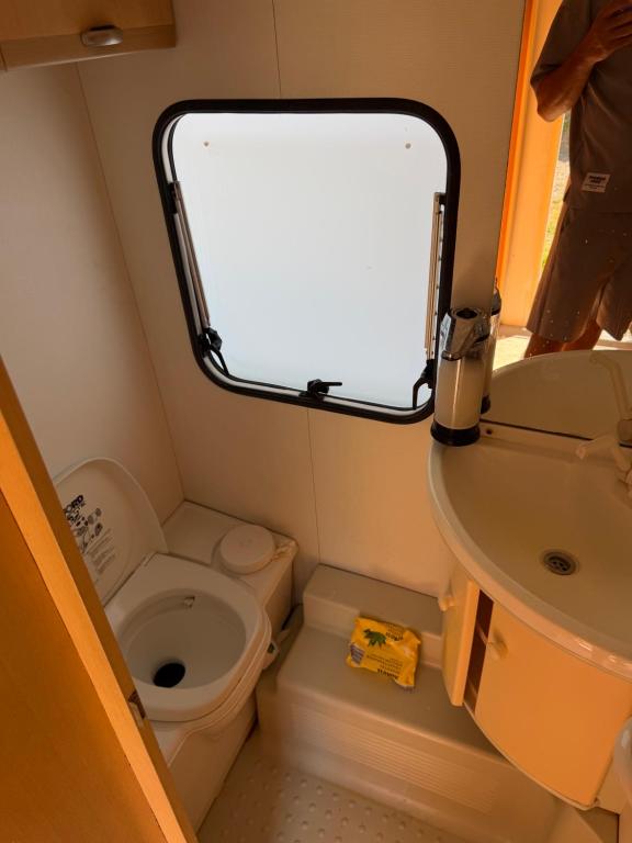 a small bathroom with a toilet and a sink at Karavan Hrdlička in Čím