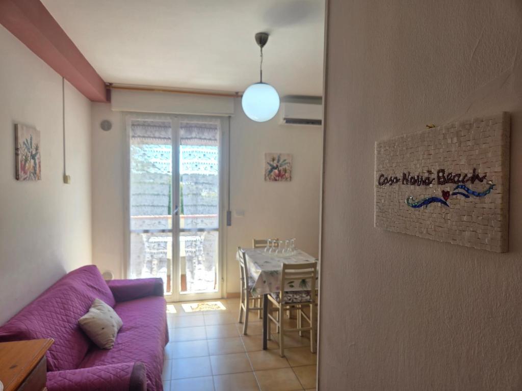 a living room with a purple couch and a table at Casa Nanà Beach in Lido Adriano
