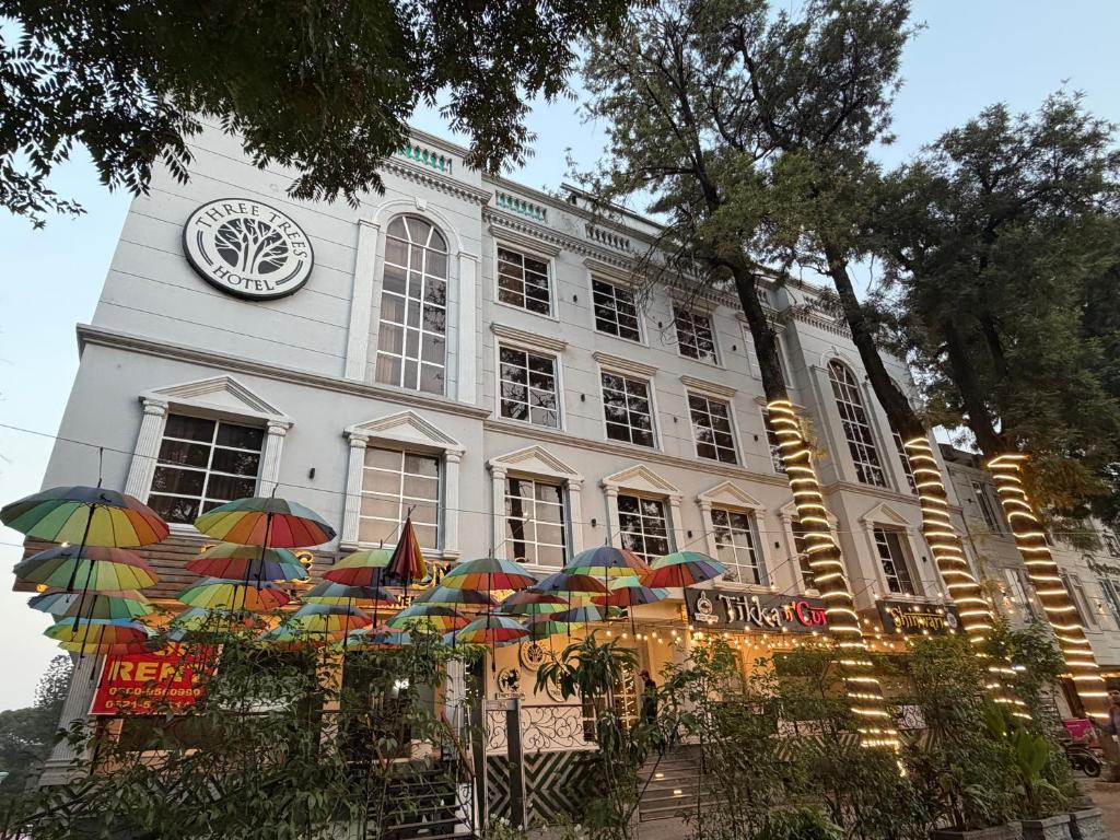 a building with a clock on top of it with umbrellas at THREE TREE Signature Hotel-G7 Markaz Islamabad in Islamabad