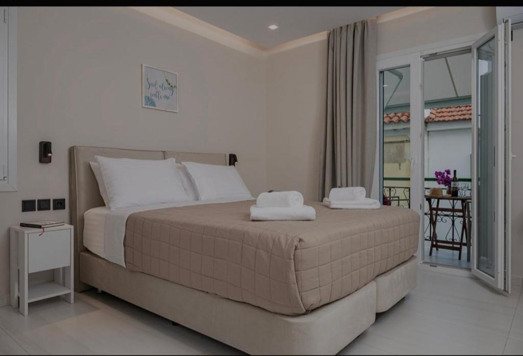 a bedroom with a bed with two towels on it at Dimitra Suites in Pythagoreio