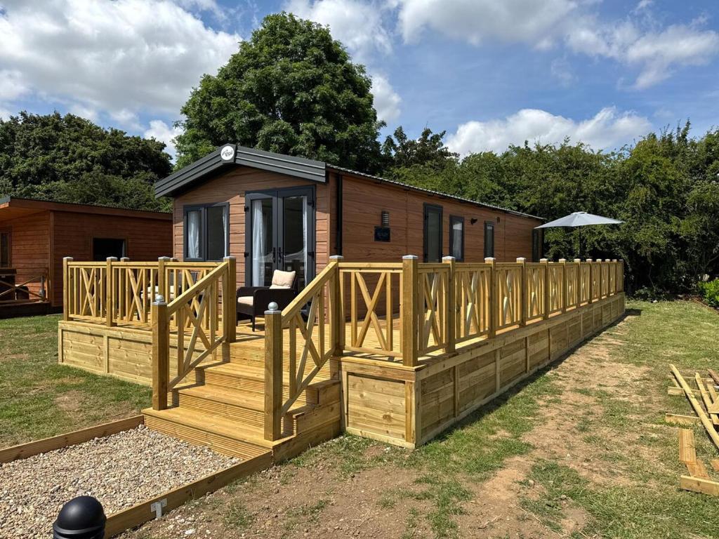 a cabin with a wooden deck in the yard at Luxury Lodge in Beverley