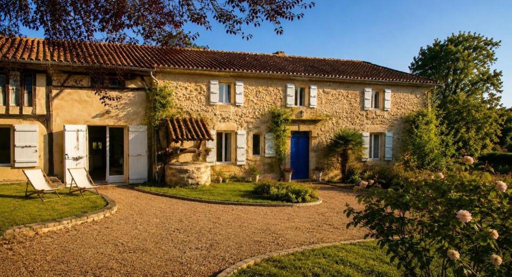 a stone house with a blue door and a yard at La Bastide de Sherlock in Troncens