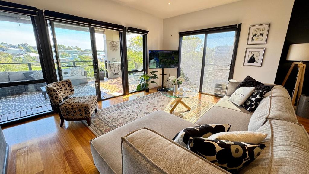 a living room with a couch and a table at Coastal Tones - Designer Beach house - Pets Welcome - Huge Yard - Walk to Beach in Cowes