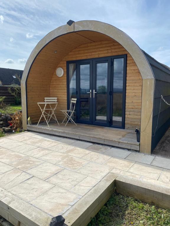 an arched building with a patio and a table at Braehead Pods in Forth