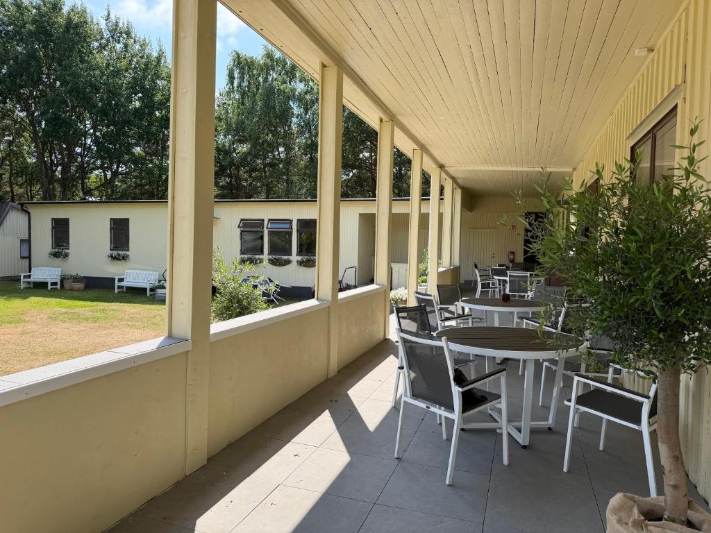 an outdoor patio with tables and chairs and windows at Seaside Stay Haverdal in Haverdal