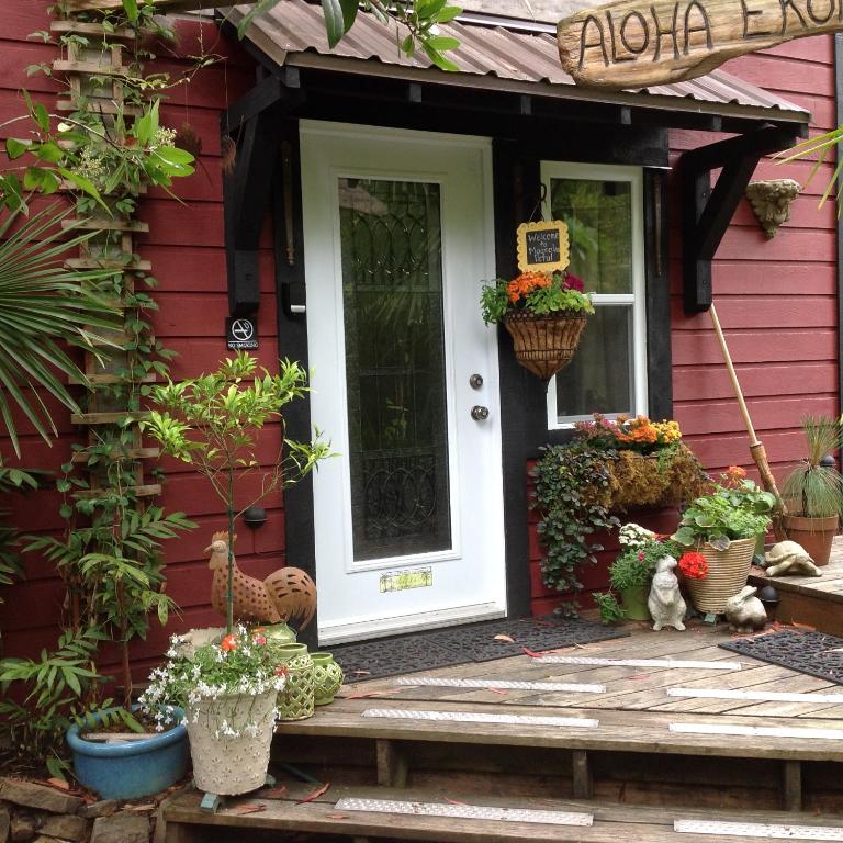 a red house with a white door and some plants at Magnolia Petal in Ganges