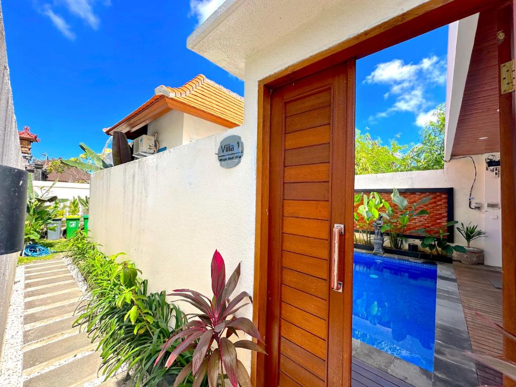 a door to a house with a swimming pool at Mesari Jinah Villa 1 - 2BR Private Pool Near Melasti Beach Uluwatu in Uluwatu
