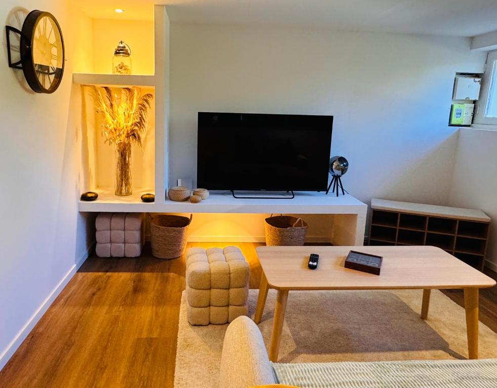 a living room with a tv and a table at Le Manana in Crozon