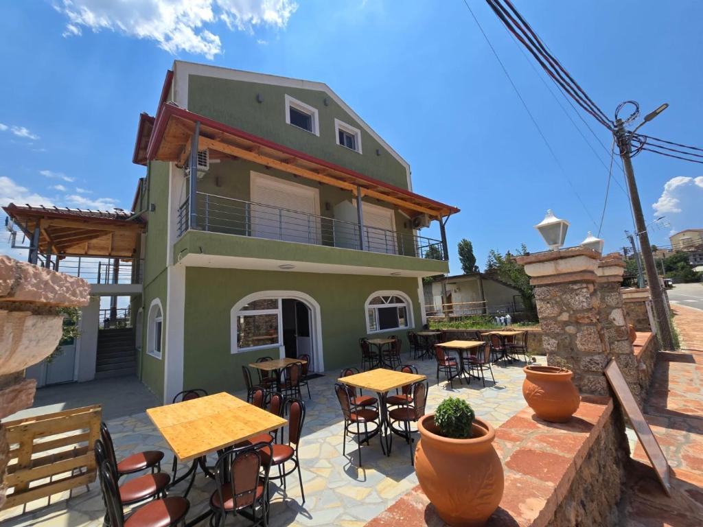 a patio with tables and chairs and a building at Vila Sokrati in Mursi