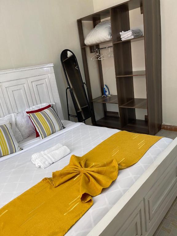 ein Bett mit einer gelben Schleife darauf in der Unterkunft Kitale Comfy in Kitale