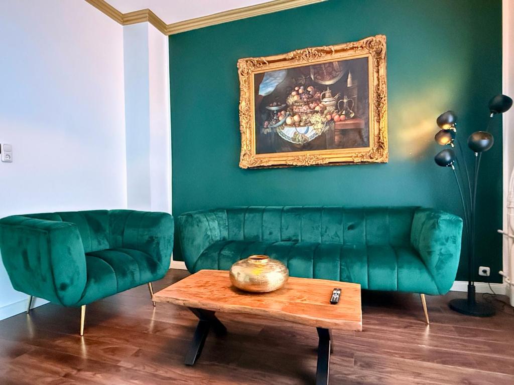 a living room with a green couch and a table at STADtPERLE in Itzehoe