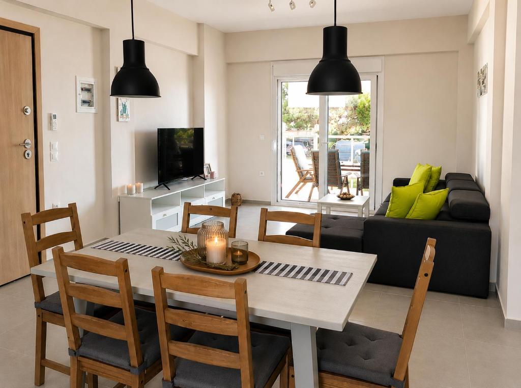 a dining room and living room with a table and chairs at Lagonisi Apartment in Skála Nikíta